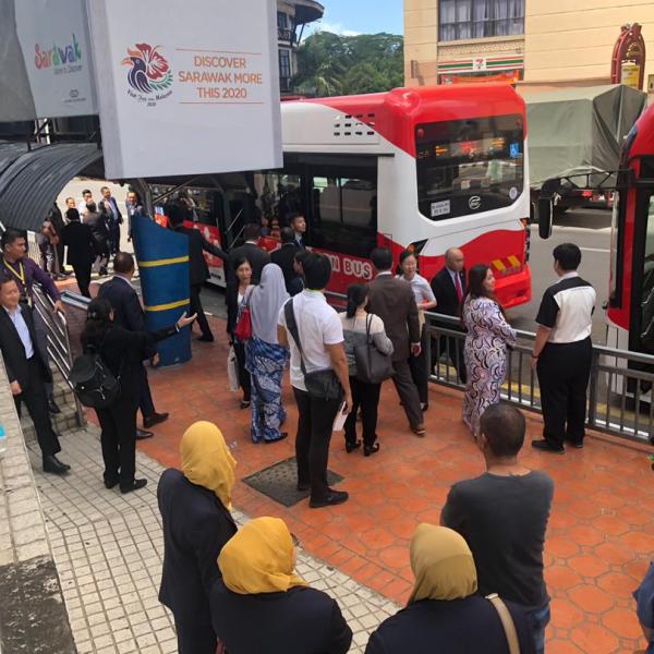 Invited guests and members of the media waiting to board the hydrogen bus during the launch of the operational trials