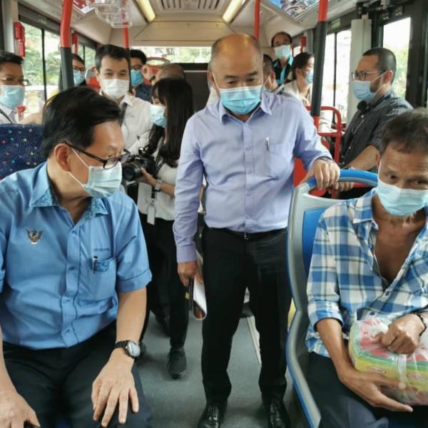 Minister of Transport Sarawak YB Datuk Lee Khim Shin (left) talking to a passenger in conjunction with the resumption of trial operations of the hydrogen bus, as Transport Ministry Permanent Secretary YBhg Datu Buckland Bangik looks on